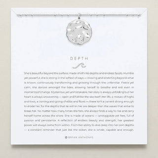 Necklace with a round pendant on a card featuring an inspirational quote by Bryan Anthony's on a beige background