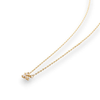 Gold necklace with a small pendant of 3 gemstones in a triangle shape on a white background