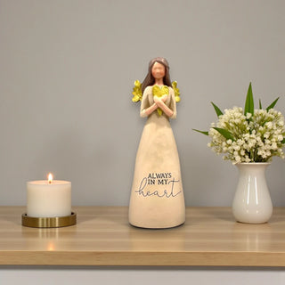 A resin angel holding a gold heart with the inscription Always In My Heart