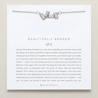 Silver necklace on a card with text and branding