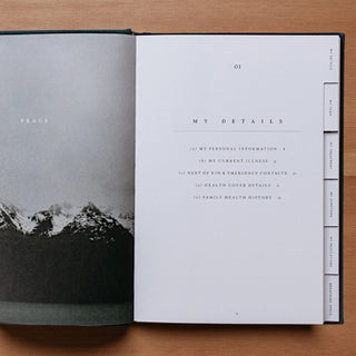 Open book with a mountain landscape on one page and text on the other, on a wooden surface.