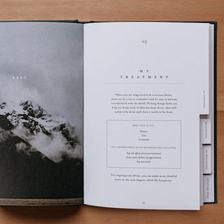 Open book with text and a black and white photograph on a wooden surface
