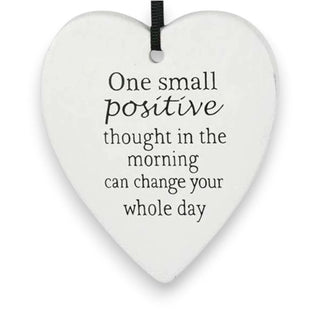 Heart-shaped white plaque with motivational quote on a white background