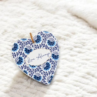 Heart-shaped decorative item with blue floral pattern and 'Love Always' text on a white textured background