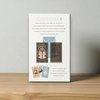 Packaging of astrological gift cards on a wooden surface with a gray backgroundb