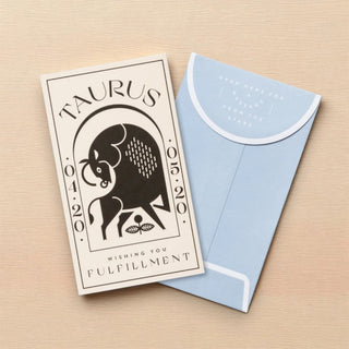 Card with Taurus zodiac design and blue envelope on a beige background