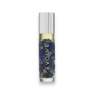 Roll-on bottle of essential oils with lapis lazuli chips and 24k gold flakes in a clear bottle with a decorative cap on a white background