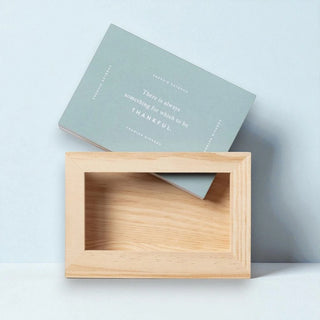 Wooden frame with a motivational quote card on a light gray background