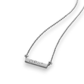 Silver necklace with a bar pendant featuring small crystals on a white background