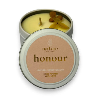 Candle in a tin with 'nurture my life honour' label on a white background