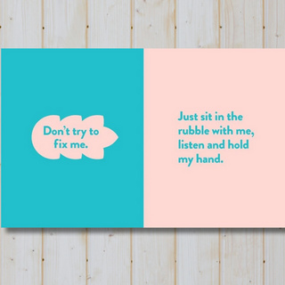 Open book with blue and pink sections featuring text on a wooden background