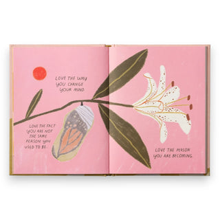 Open book with floral illustrations and motivational text on a pink background