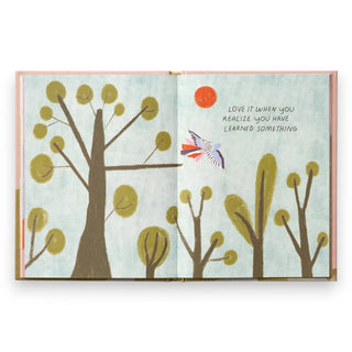Illustrated book open to a page with trees and a bird, featuring a motivational quote.