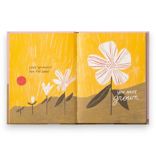 Open book with floral illustrations and motivational text on a yellow background