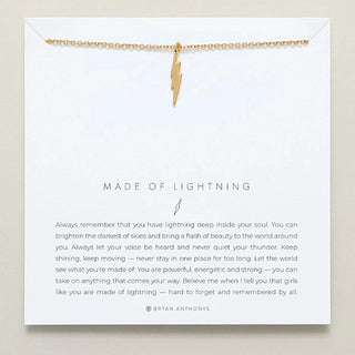 Gold lightning bolt necklace on a card with text