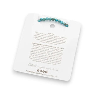 Turquoise beaded bracelet on a white card with text and branding