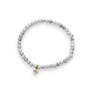 Gray beaded bracelet with a gold charm on a white background