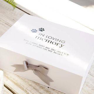 Memorial box for a pet with text and paw prints on a wooden surface