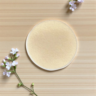 Round beige product on a wooden surface with white flowers