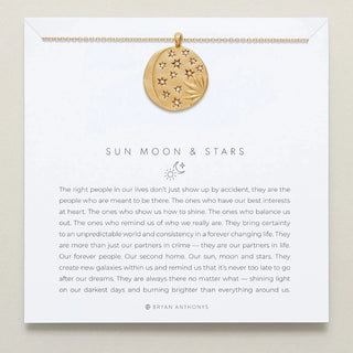 Gold necklace with a round pendant with stars and gems on it on a card with text