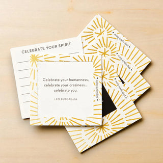 Set of greeting cards with gold geometric designs on a wooden surface