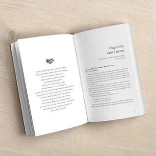 Open book on a wooden surface with text and a logo.